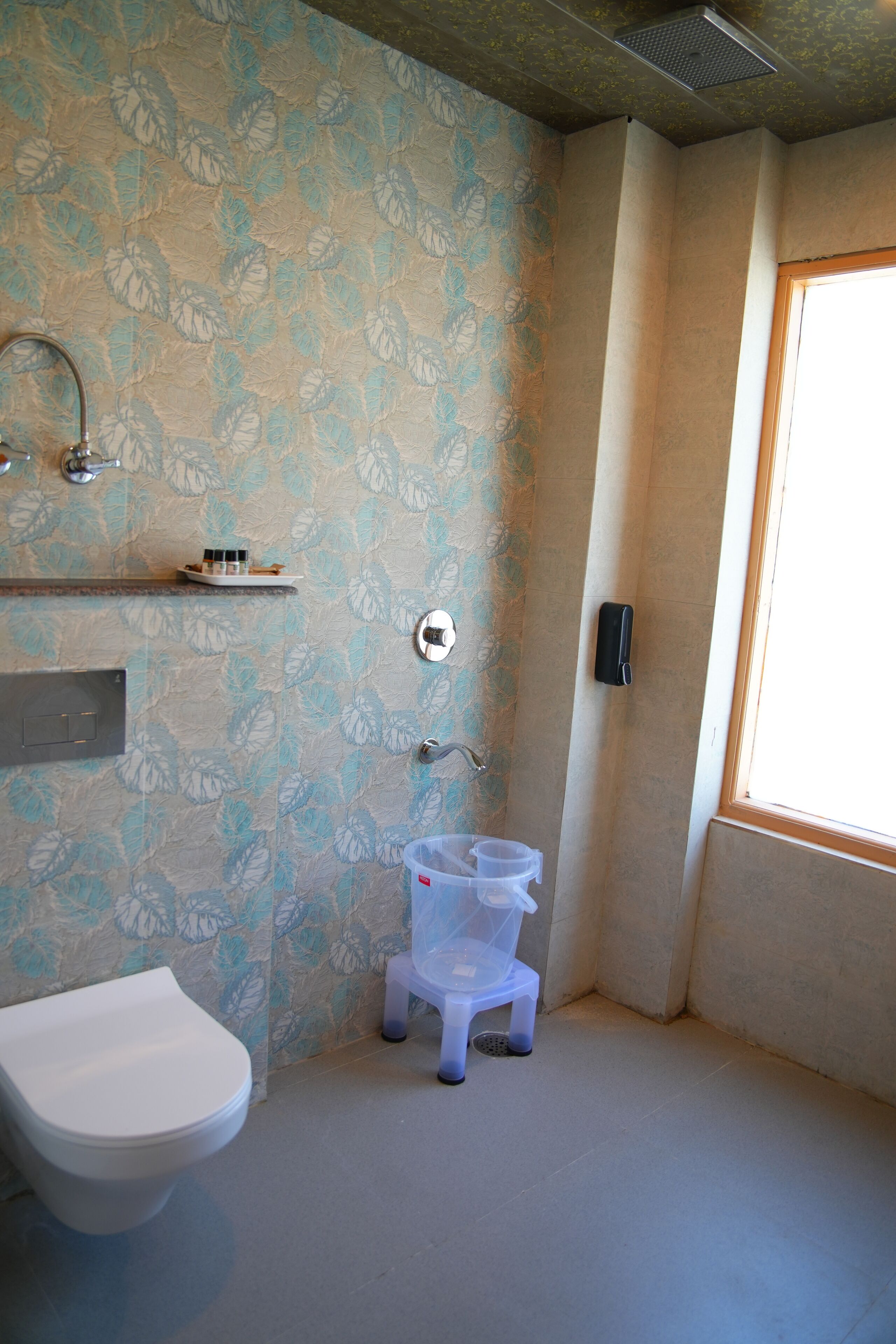 A bathroom with a toilet, a sink, a shower, and a window.