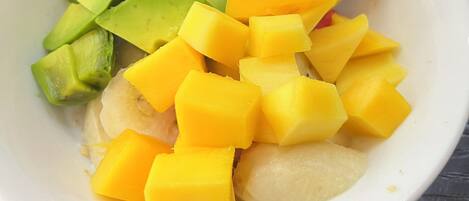 A bowl of fruit salad with a spoon.