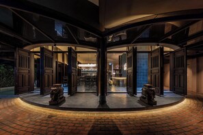 A circular lobby with open doors leading to a bar area, featuring a central pillar and two decorative urns. - Heritage Gem Boutique Villa (Da Nang)