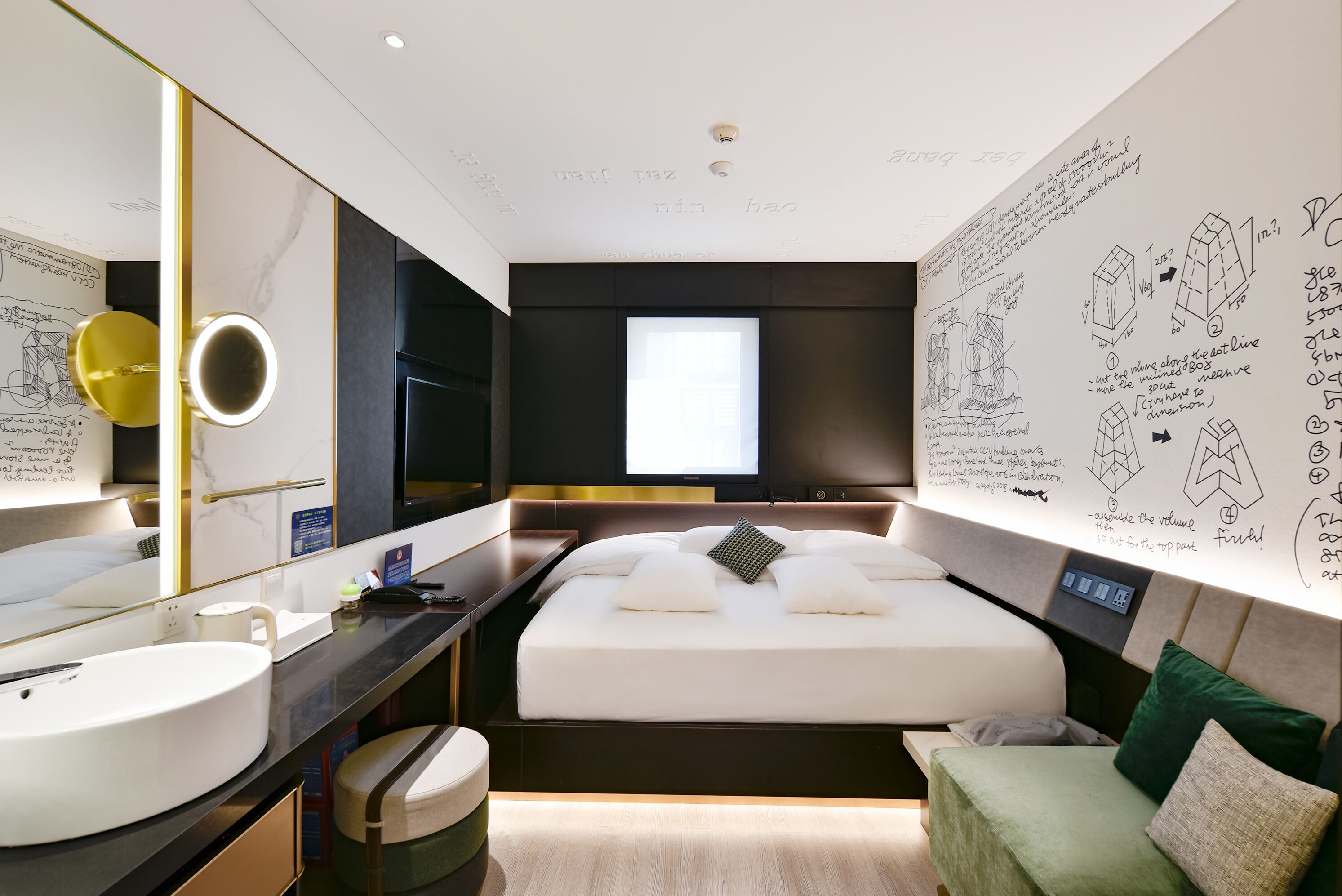 Une chambre d’hôtel moderne, dotée d’un grand lit, d’une table de chevet, d’un miroir, d’un lavabo et d’une fenêtre.