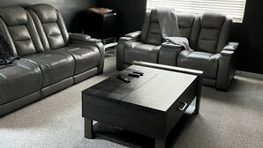 A modern living room with a sectional sofa, a recliner, and a coffee table. - Luxury Glendale Stay with Pool & Theater Room by Cardinals Stadium (Glendale)