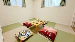 A traditional Japanese room with tatami flooring, a low wooden table with tea set, and shoji screens. - Hao Bros.Home Gemini (Tokyo)