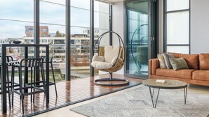 Ein modernes Wohnzimmer mit einem Hängesessel, einer Couch und einem Couchtisch.