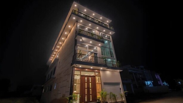 A multi-story building with balconies, large windows, and a well-lit entrance. - Heaven Grand Ayodhya (Sohawal)