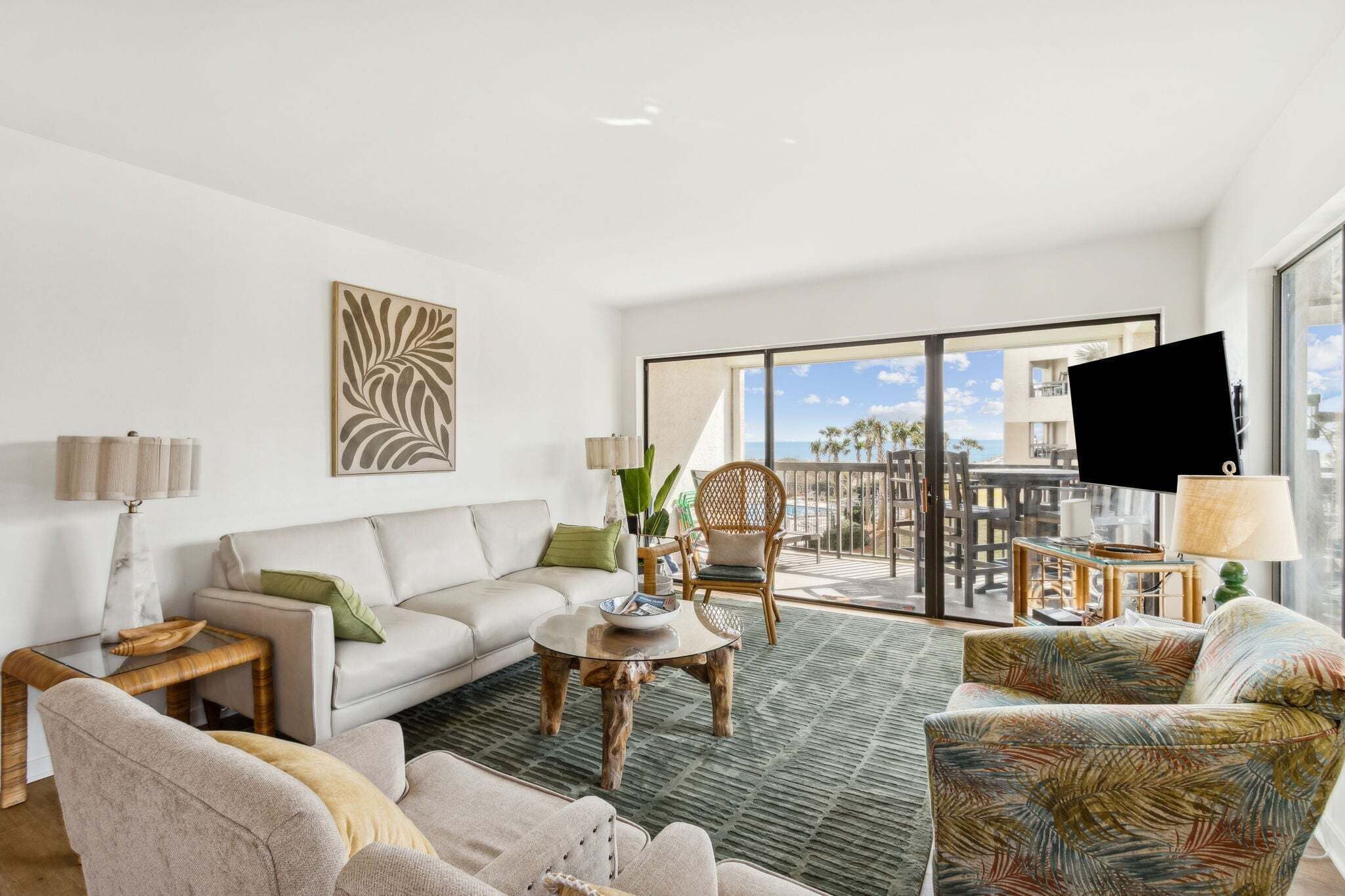 A modern living room with a sofa, chairs, a coffee table, and a large window with a view.