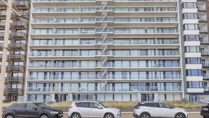 A multi-story building with balconies, a stairwell, and parked cars. - Apartment on the 8th floor with terrace (Middelkerke)