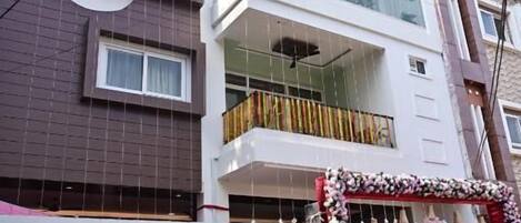 A multi-story building with a modern architectural design, featuring balconies and large windows.