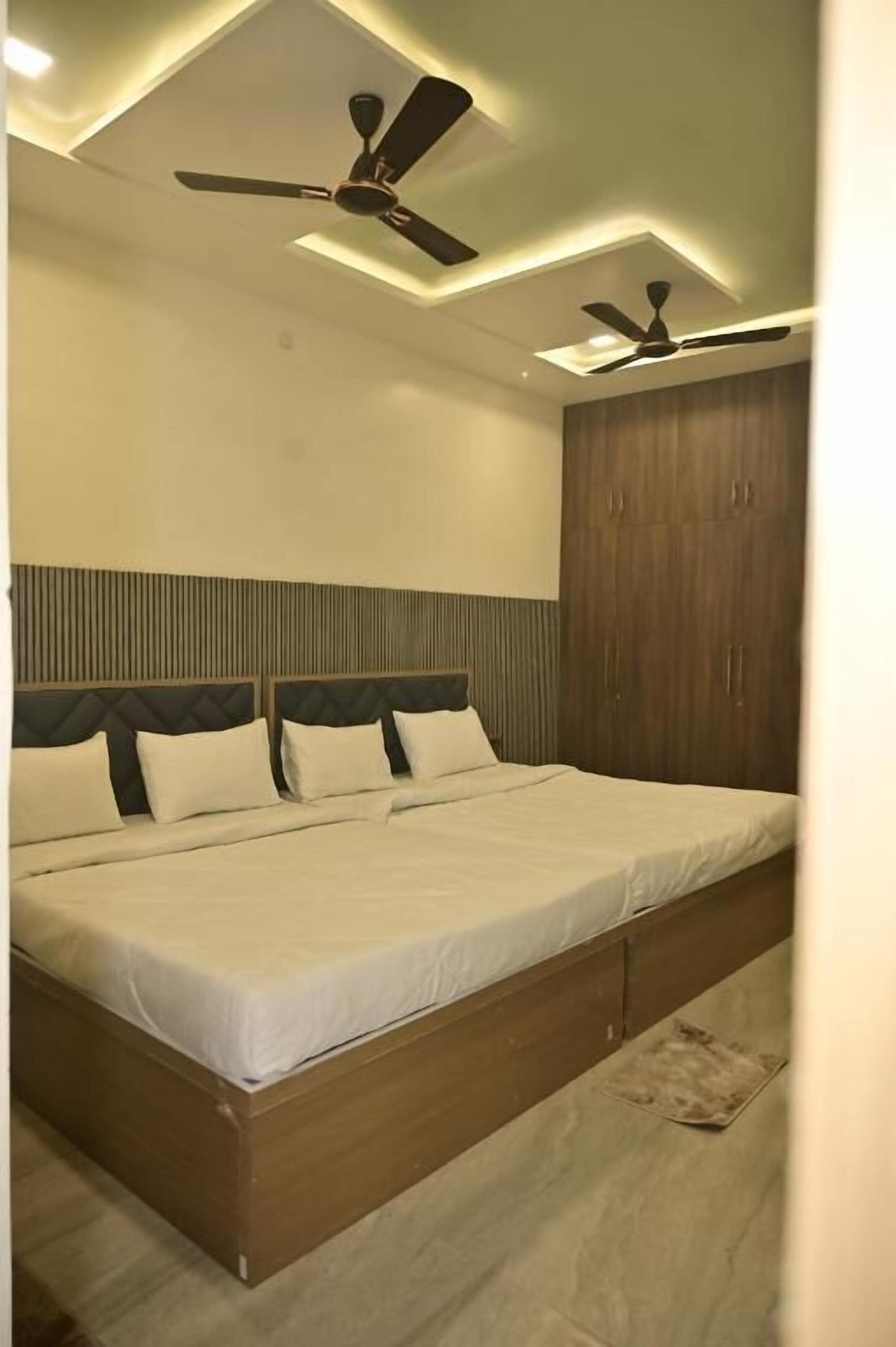Une chambre à coucher avec un lit, des ventilateurs de plafond et une armoire.