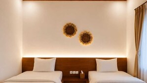 A hotel room with two beds, wooden ceiling, and wall decor.