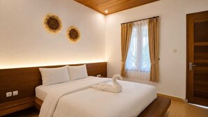 A modern bedroom with a wooden ceiling, a large bed with a swan-shaped pillow, and two wall-mounted decorative sunflowers.