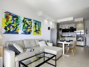 Ein modernes Wohnzimmer mit Sofa, Couchtisch und abstrakter Kunst an der Wand.
