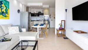 A modern living room with a sofa, coffee table, and a flat-screen TV. - Sunstay Benalbeach Juana Flat I Benalmadena (Benalmádena)