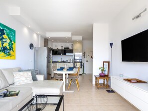 Ein modernes Wohnzimmer mit Sofa, Couchtisch und Flachbildfernseher.
