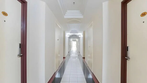 Un largo y estrecho pasillo de hotel con puertas a ambos lados, cada una con un número.