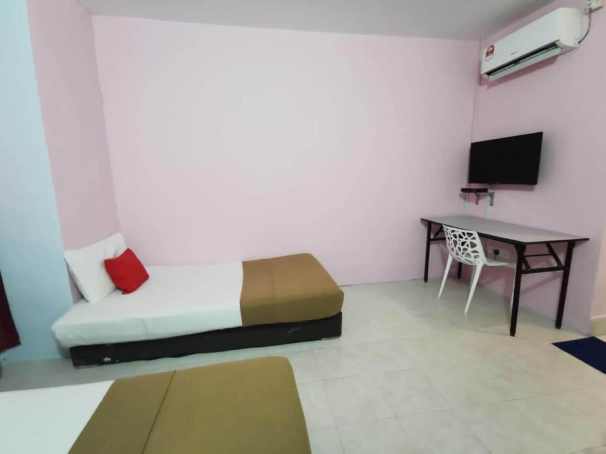 A small room with a bed, a desk, a chair, and a TV.