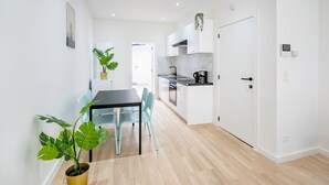 A modern kitchen with white cabinets, a black countertop, and a potted plant. - Cosy Apartment in Central Antwerp (Antwerp)