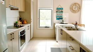 Eine moderne Küche mit Backofen, Spüle und Fenster.
