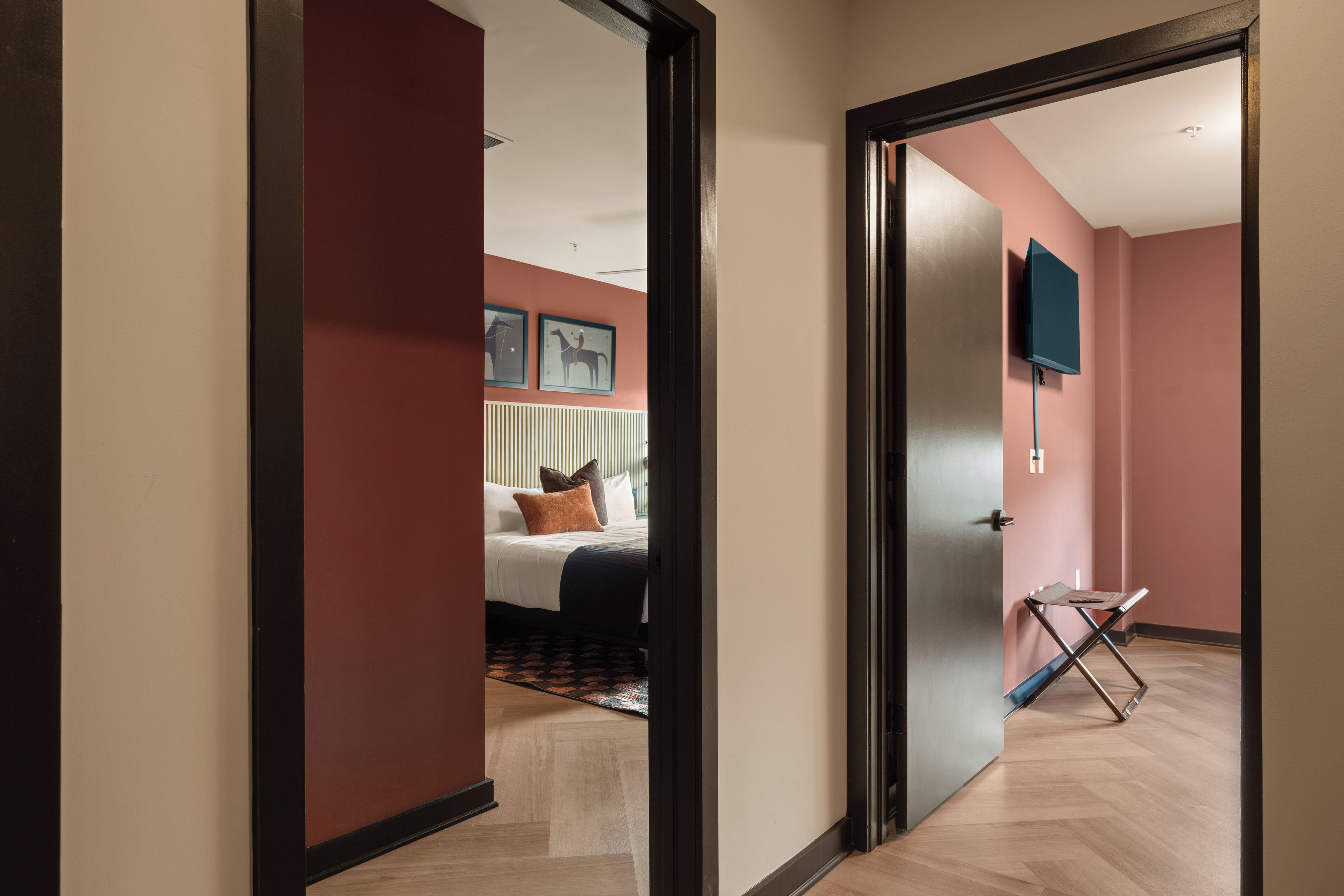 Una habitación de hotel con cama, escritorio y televisor en la pared.