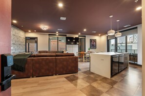 A modern kitchen with a central island, a dining area with a table and chairs, and a seating area with a sofa. - Superior Suite - Unit 202 (Nashville)