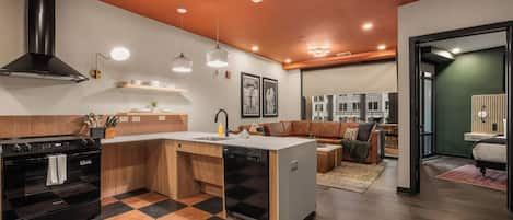 A modern kitchen with a central island, wooden cabinetry, and a black stove.