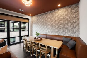 A modern interior with a dining area, a sofa, and a view of the outside. - Superior Suite - Unit 306 (Nashville)