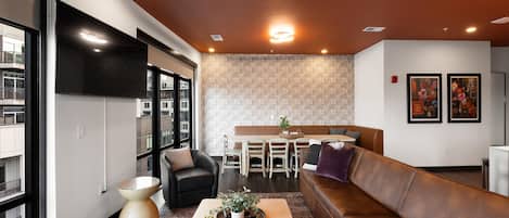Una sala de estar moderna con sofá, mesa de centro y comedor con sillas y una mesa.