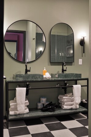 A bathroom with two sinks, a mirror, and a towel rack. - Superior Suite - Unit 401 (Nashville)