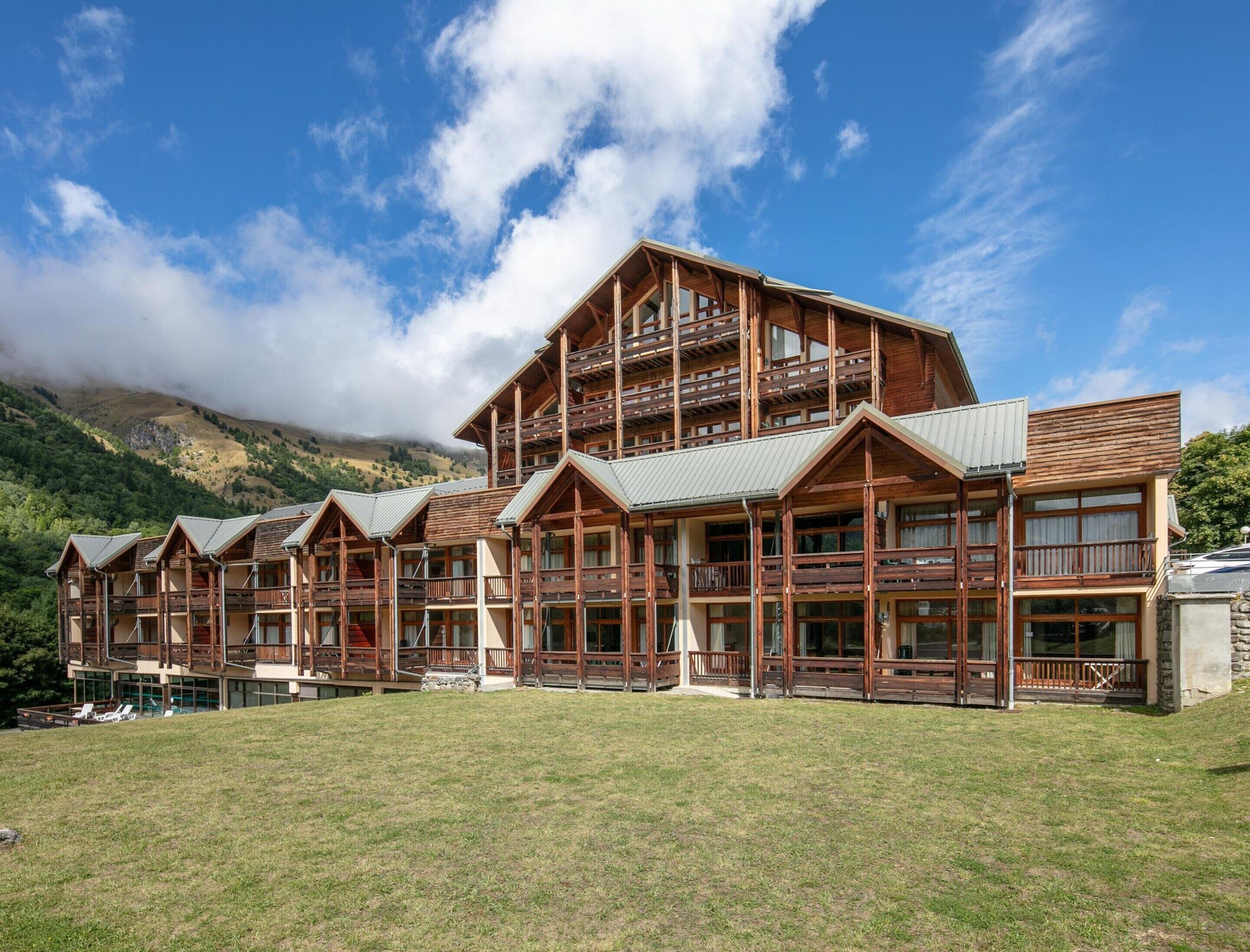 A multi-story lodge with wooden architecture, balconies, and large windows.