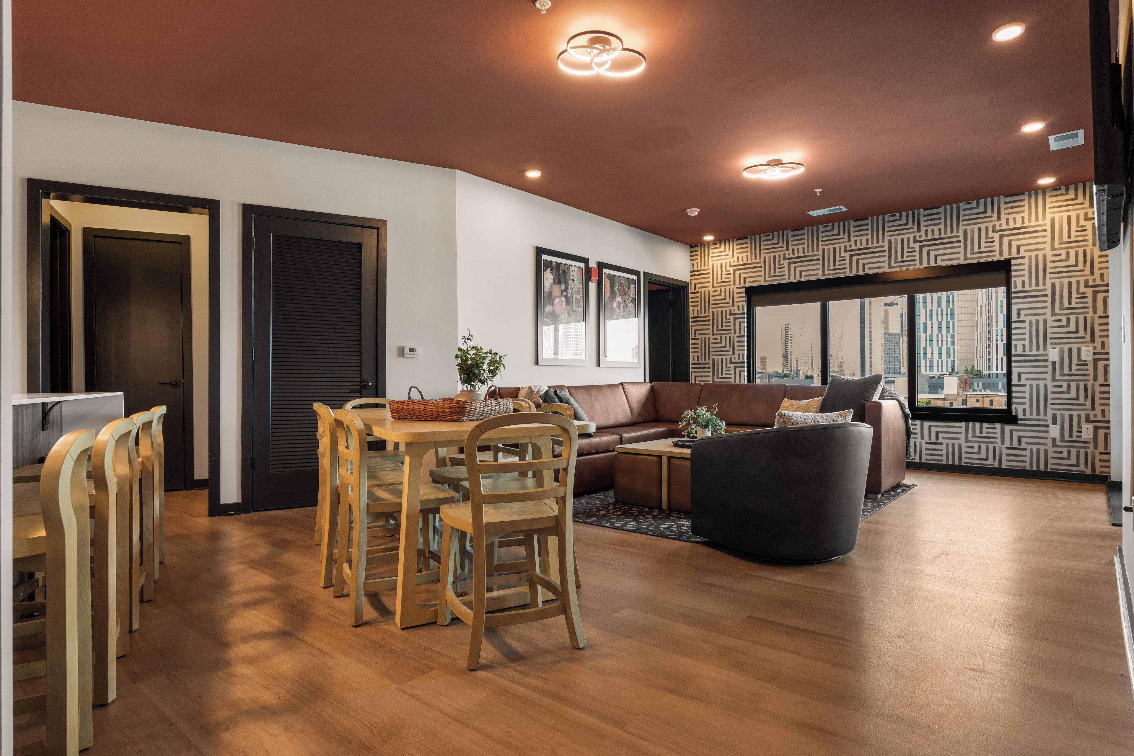 Ein modernes Wohnzimmer mit Essbereich, ausgestattet mit einer Couch, einem Couchtisch und einem Esstisch mit Stühlen.