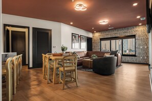 A modern living room with a dining area, featuring a sofa, a coffee table, and a dining table with chairs. - Superior Suite - Unit 403 (Nashville)