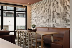 A modern interior with a dining area, a sofa, and a patterned wall. - Superior Suite - Unit 406 (Nashville)