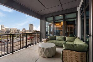 A balcony with a city view, a sofa, and a round table. - Superior Suite - Unit 503 (Nashville)