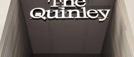 The exterior of The Quinley hotel with a prominent sign above the entrance.