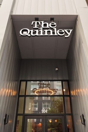 La façade de l’hôtel The Quinley, avec une enseigne bien visible au-dessus de l’entrée.
