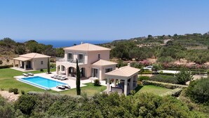 Een villa met zwembad, meerdere kamers en uitzicht op zee.