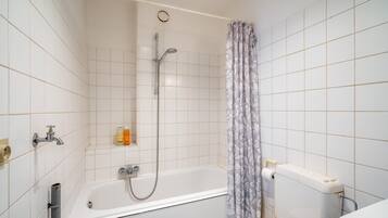 A bathroom with a bathtub, shower, toilet, and a curtain.