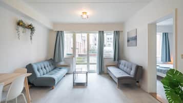 Een moderne woonkamer met twee banken, een tafeltje en een eethoek.