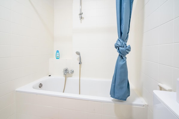 Une salle de bain avec une baignoire, une douche et des toilettes.