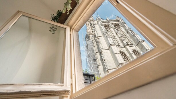 A window with a view of a Gothic-style building. - Temple Triplex Spacious Apartment (Antwerp)