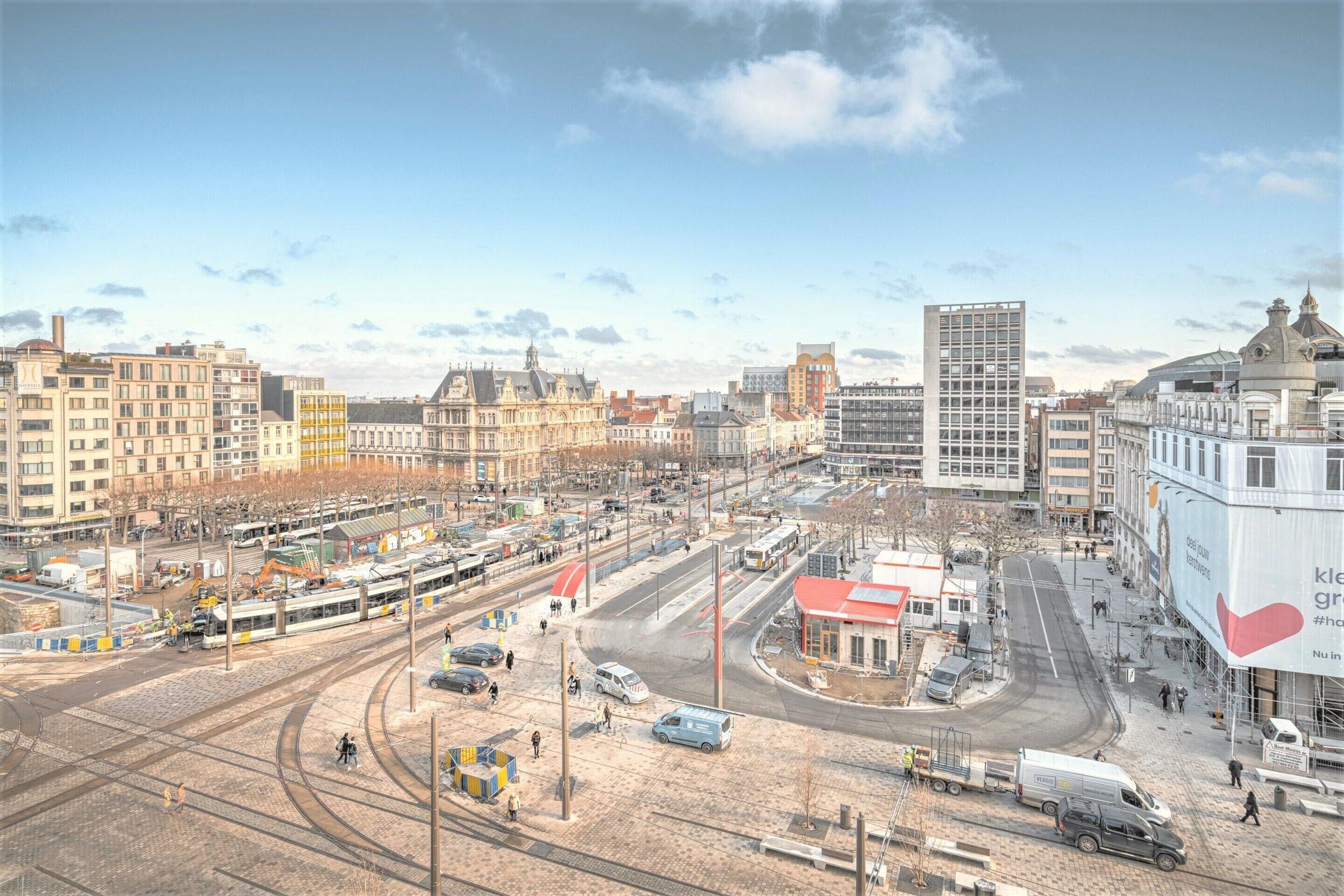 A cityscape with a tram line, buildings, and a large billboard.