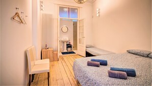 A room with a bed, a chair, a small table, a radiator, and a door leading to another room. - Bright Lodge 6-person Antwerp (Antwerp)