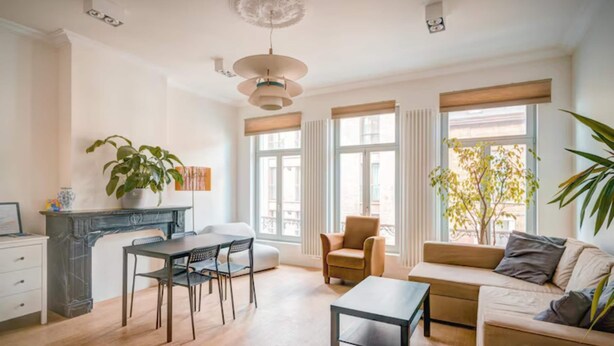 A modern living room with a sofa, coffee table, dining table, chairs, and a fireplace. - Bright Lodge 6-person Antwerp (Antwerp)