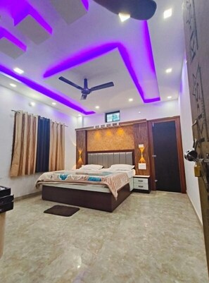 Una camera da letto con un letto, comodini, una ventola a soffitto e illuminazione LED viola.