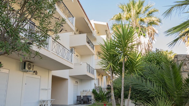 A multi-story residential building with balconies, outdoor seating, and palm trees. - Goldie Home by RentalsPro - Kallithea Halkidiki (Kallithea)