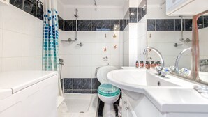 A bathroom with a bathtub, a toilet, and a sink. - Goldie Home by RentalsPro - Kallithea Halkidiki (Kallithea)