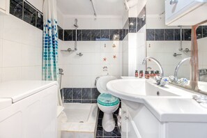 A bathroom with a bathtub, a toilet, and a sink. - Goldie Home by RentalsPro - Kallithea Halkidiki (Kallithea)