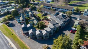 Un quartier résidentiel comprenant plusieurs maisons, un grand immeuble avec un toit bleu et un parking.