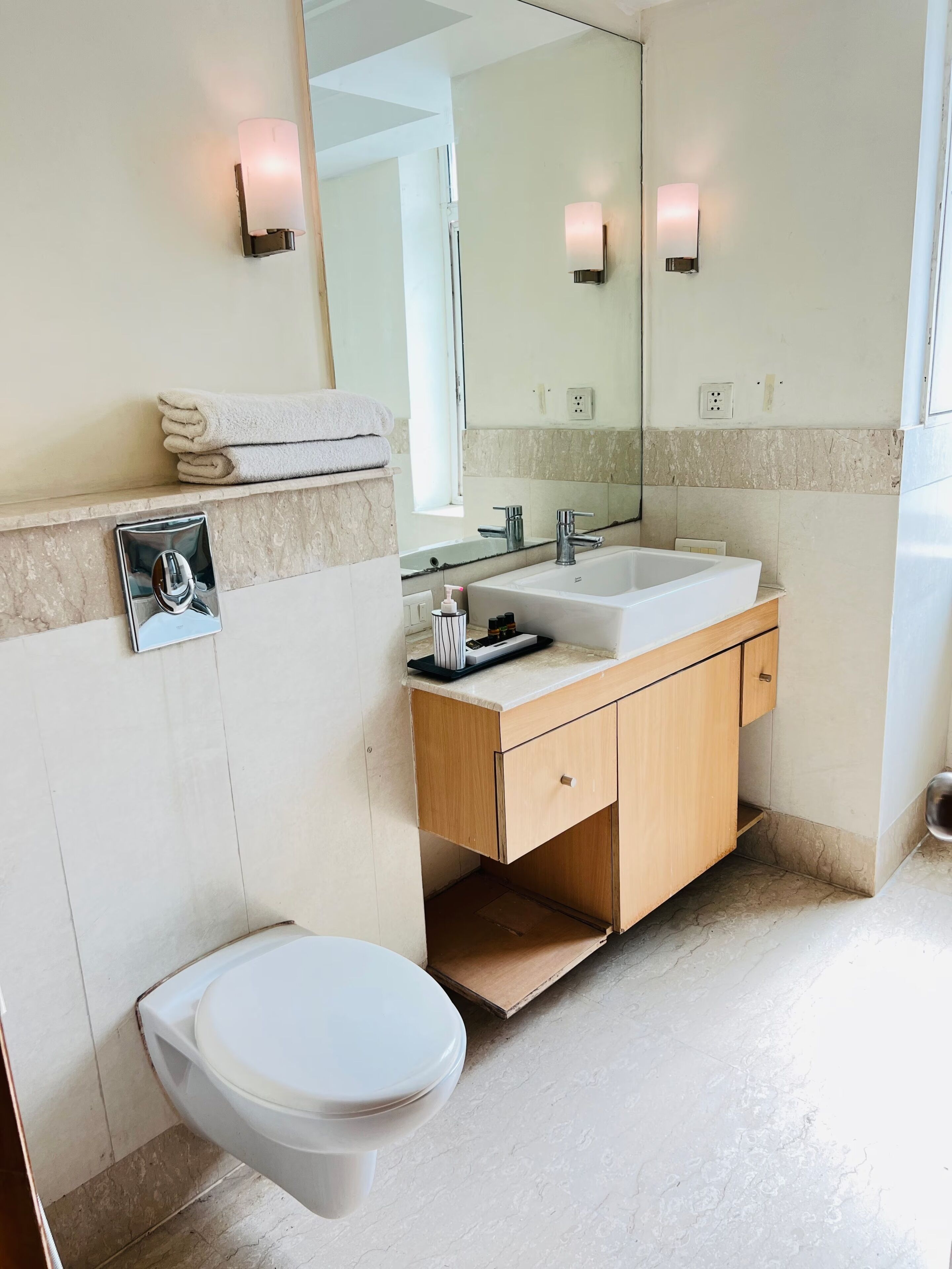 A modern bathroom with a toilet, sink, and mirror.