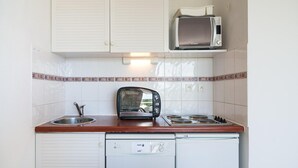 A compact kitchenette with a microwave, toaster, sink, and a small dishwasher. - Golfside Apartment With Terrace (Agde)