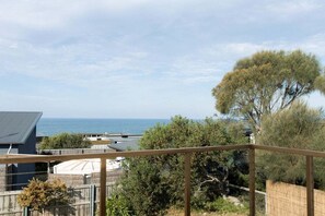 A residential area with a view of the sea, a fenced yard, and a house with a grey roof. - Beach Haus Falmouth - Family Friendly Holiday Home (Break O'Day)